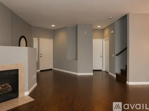 A spacious living room with a fireplace and hardwood floors.