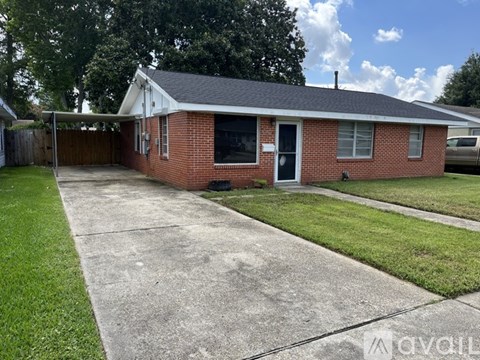 A brick house with a black door and a grey roof.