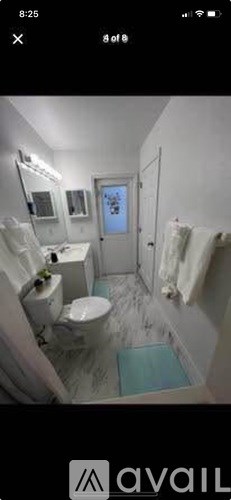 A bathroom with a toilet, sink, and mirror.