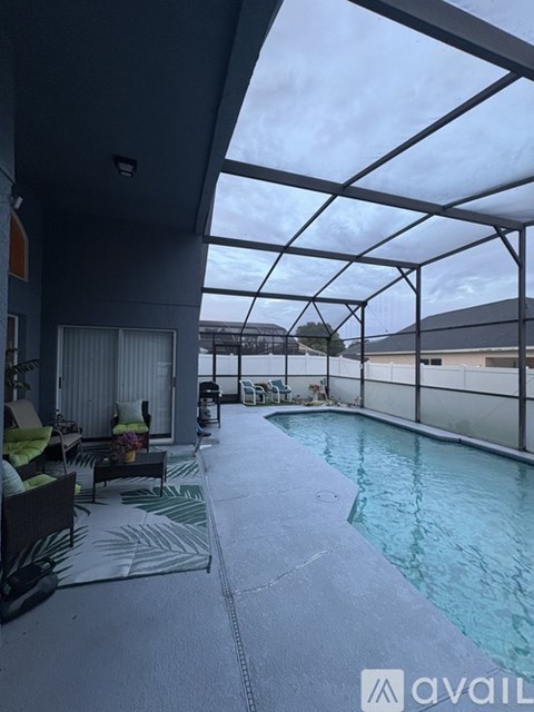 A modern indoor swimming pool area with a glass ceiling and a view of the outdoors.