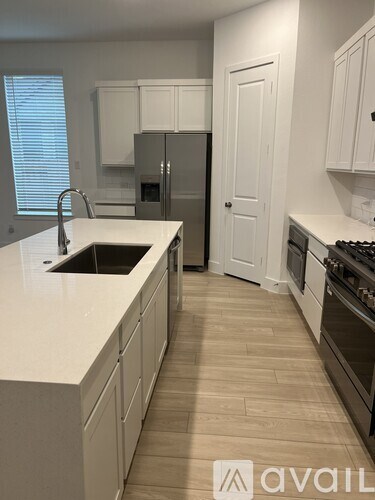 A kitchen with white cabinets and a white counter top.