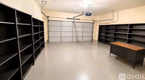 A spacious garage with a bench and shelving units.