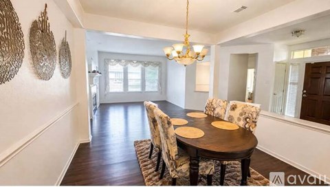 A dining room with a round table and chairs.