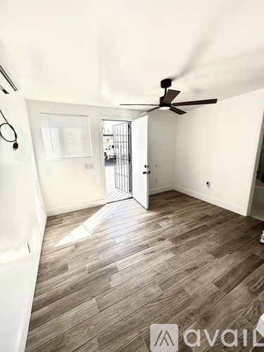 A room with a ceiling fan and wooden flooring.