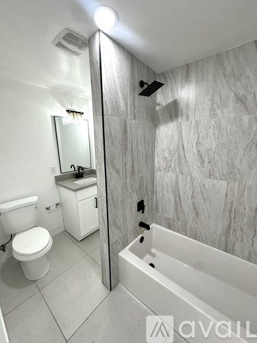 A bathroom with a toilet, sink, and bathtub.