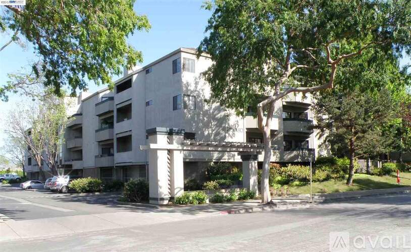 A modern apartment building with a parking lot in front.