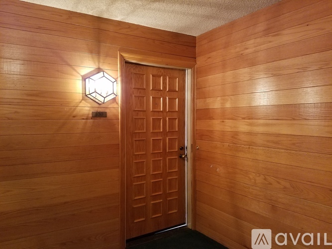 A wooden door with a hexagonal light on the wall.