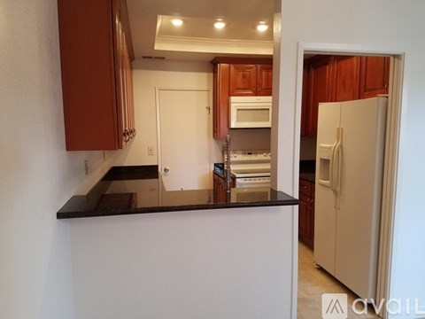A kitchen with brown cabinets and a white counter.