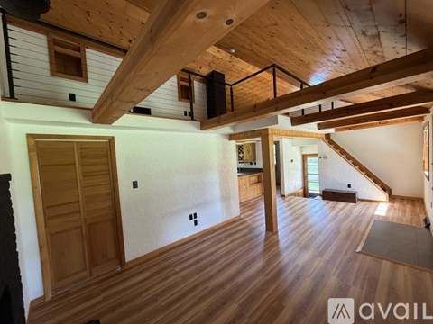 A wooden floor and ceiling with a staircase on the right side.