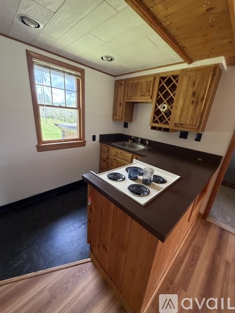 A kitchen with wooden cabinets and a black countertop.