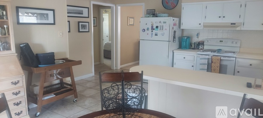 A kitchen with white appliances and a wooden table.