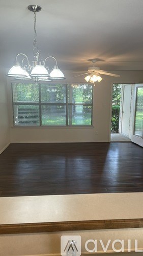 A room with a wooden floor and a chandelier.