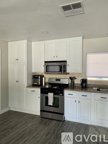 A kitchen with white cabinets and a stainless steel oven.
