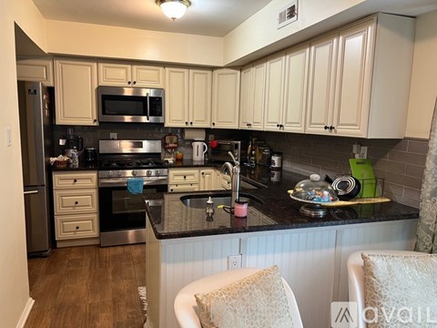 A kitchen with a black counter top and white cabinets.