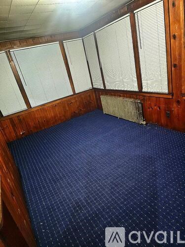 A room with a blue carpet and wooden walls.