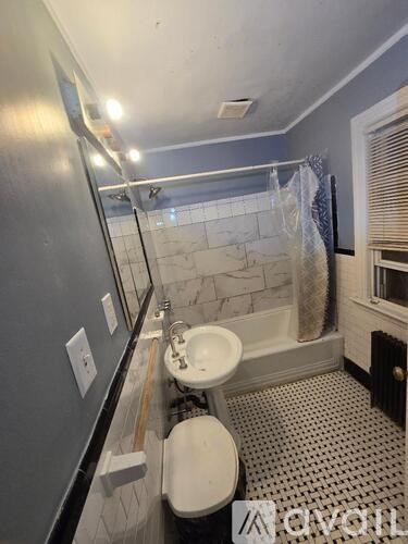 A bathroom with a toilet, sink, and shower.