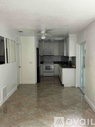 A kitchen with tile flooring and a ceiling fan.