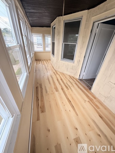 A room with wooden floors and windows on the side.