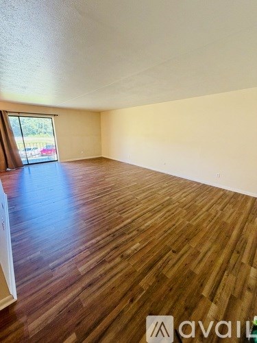 A room with wooden flooring and a window.