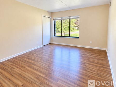 A bedroom with a bed and wooden flooring.