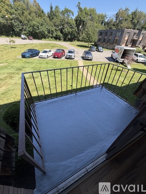 A balcony with a metal railing and a pool in the middle.