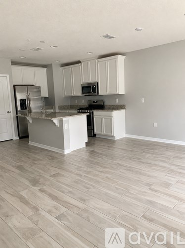 A kitchen with a refrigerator, microwave, and oven.