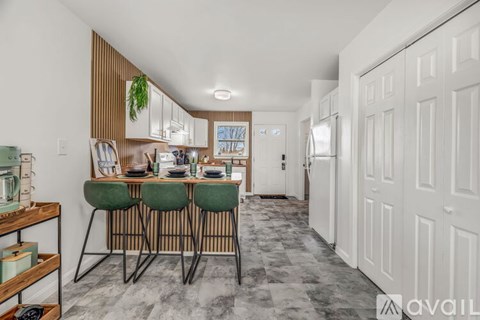 A kitchen with a dining table and chairs in the middle of the room.