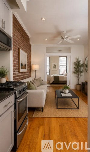 A modern kitchen with a brick wall and wooden floors.