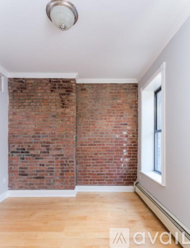 A room with a brick wall and wooden floor.