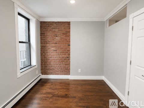 A room with a brick wall and wooden flooring.