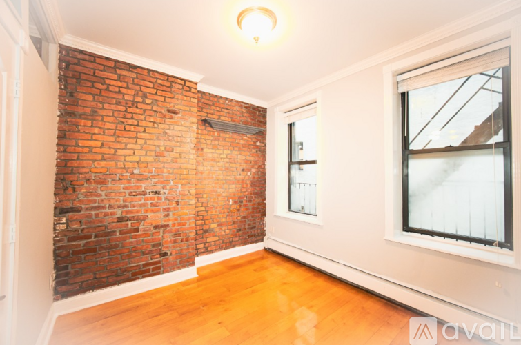 A room with a red brick wall and wooden flooring.