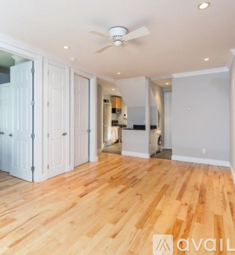 A room with wooden floors and a ceiling fan.