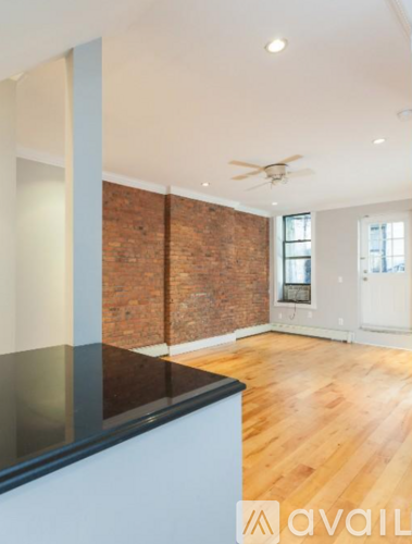 A room with a brick wall and wooden flooring.