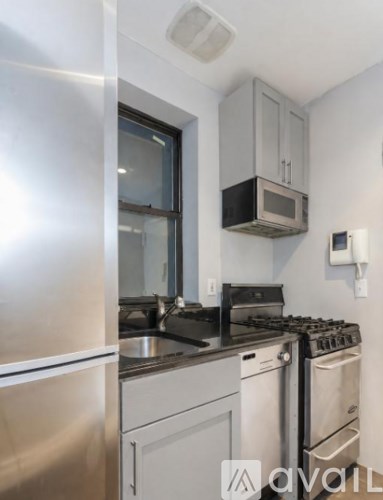 A kitchen with a stainless steel refrigerator, a stove, and a microwave.
