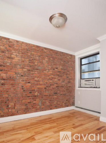 A room with a brick wall and wooden flooring.