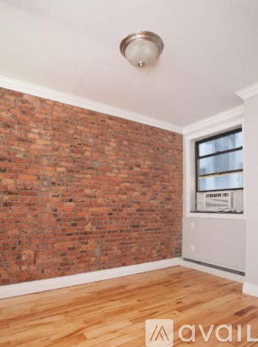 A room with a brick wall and wooden flooring.
