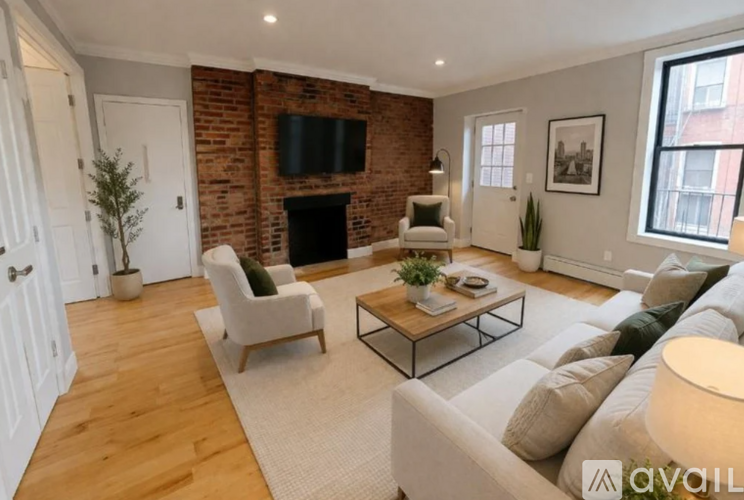 A living room with a brick wall and a fireplace.