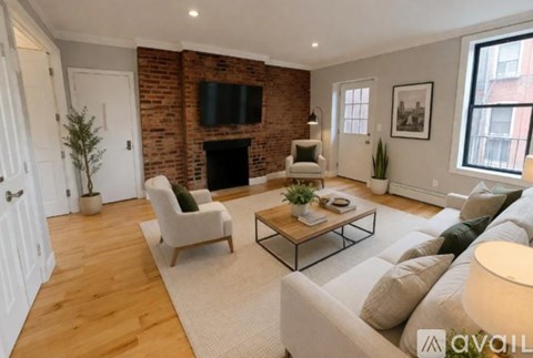 A living room with a brick wall and a fireplace.