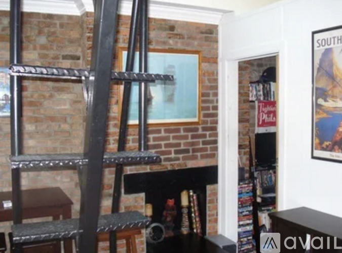 A fireplace with a brick wall behind it and a poster on the wall.