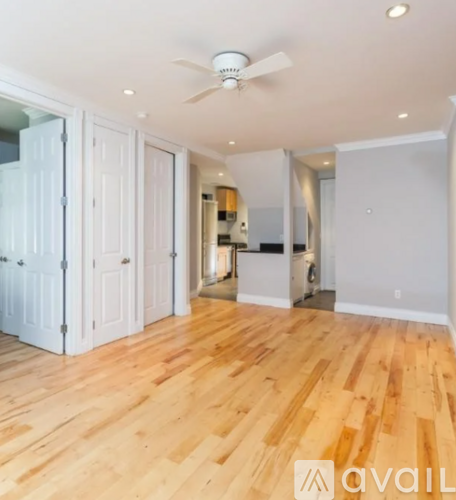A room with wooden floors and a ceiling fan.