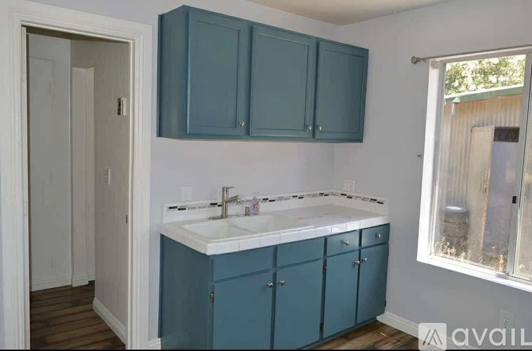 A bathroom with a white sink and blue cabinets.