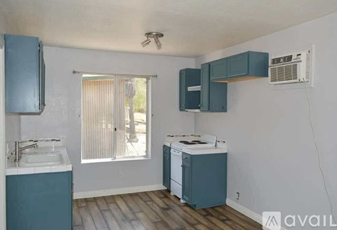 A kitchen with a sink, window, and cabinets.