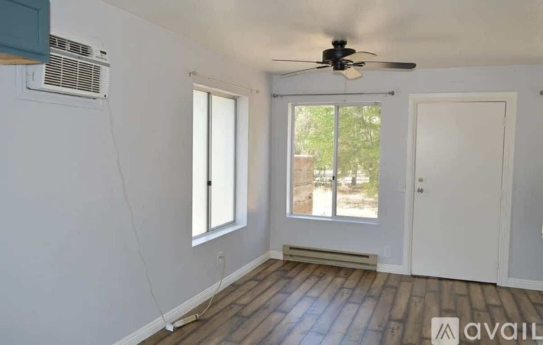 A room with a ceiling fan, a window, and a door.