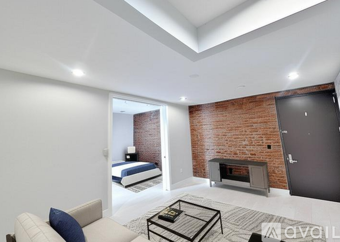 A modern living room with a brick wall and a fireplace.