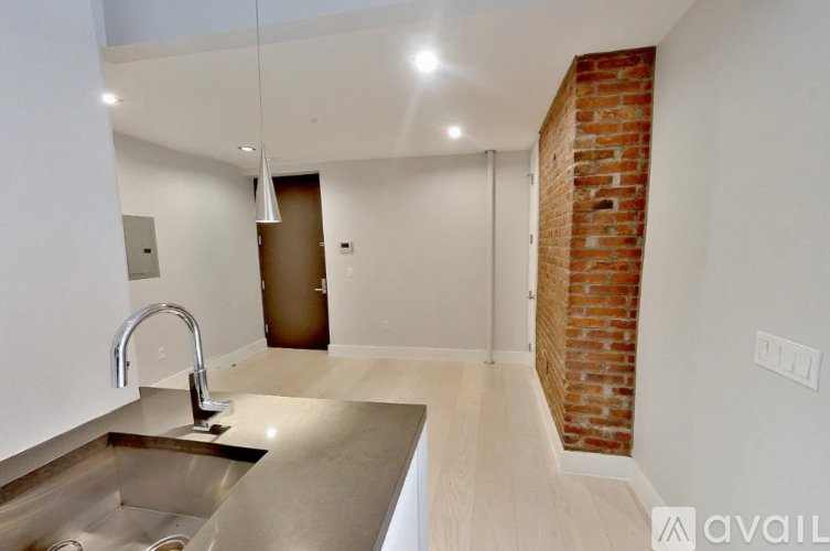 A kitchen with a brick wall and a sink.