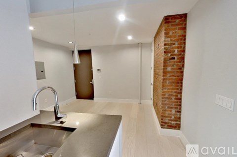 A kitchen with a brick wall and a sink.