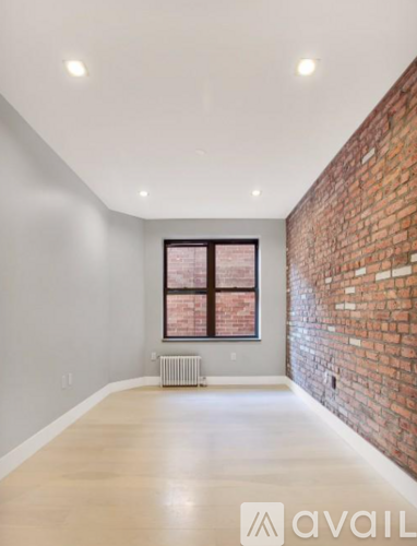 A room with a brick wall and a window.