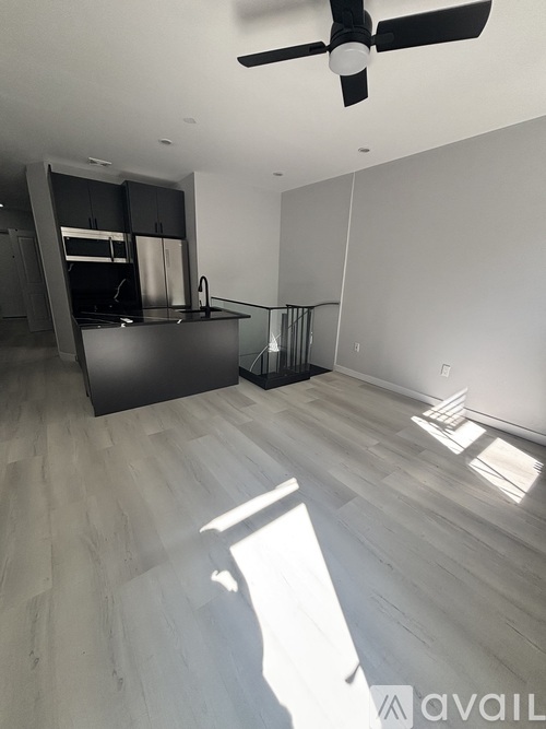 A spacious room with a ceiling fan and lighting fixtures.