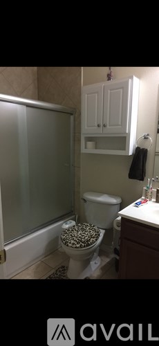 A bathroom with a toilet, a shower, and a sink.