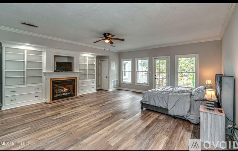 A bedroom with a fireplace and a television.